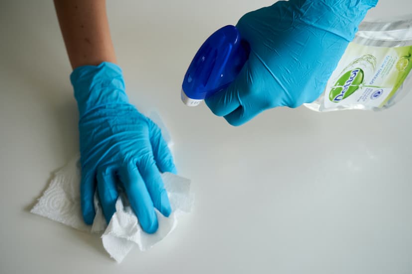 a person's hand cleaning table